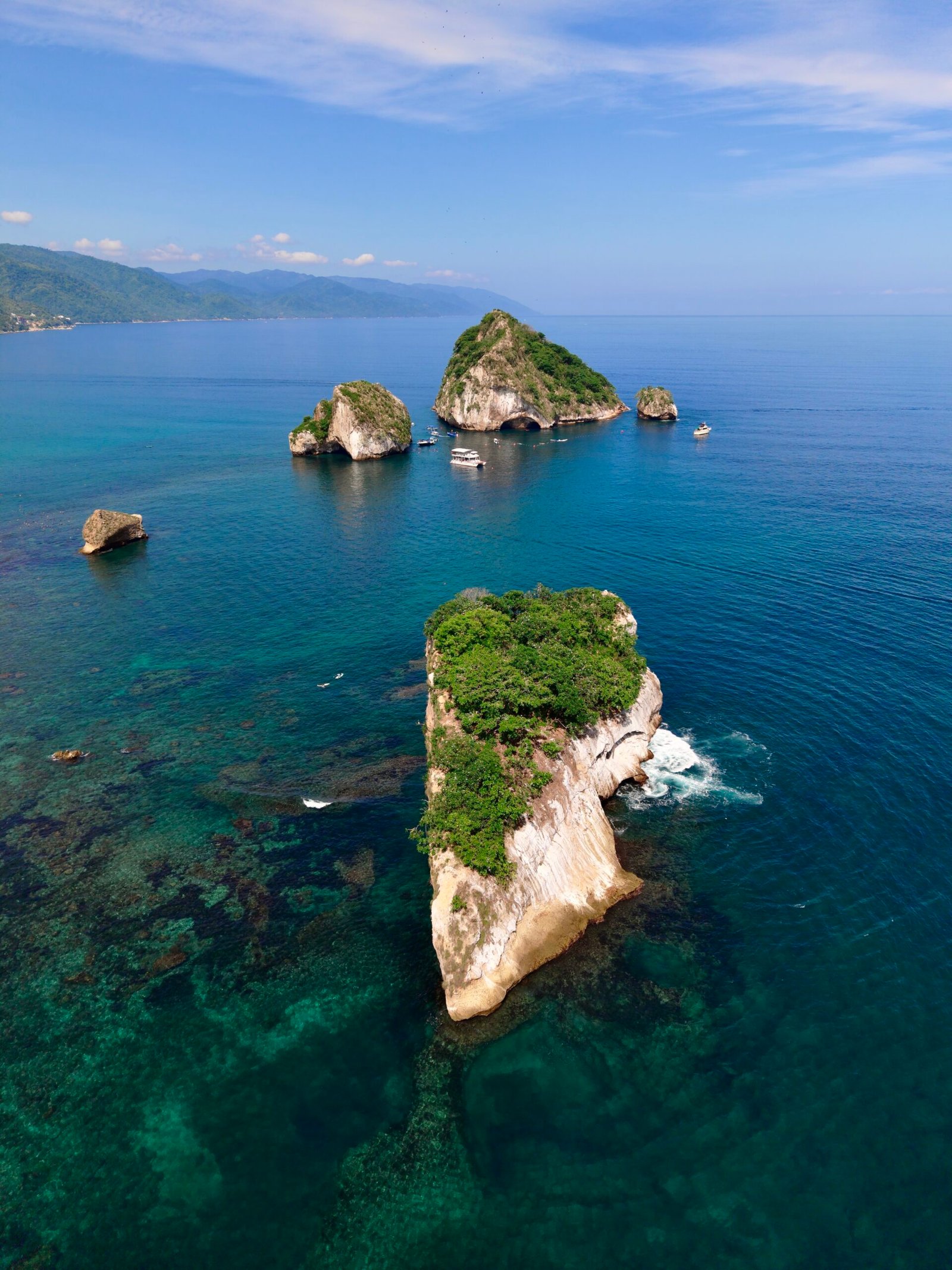 Calm warm water and lush green coastline near Los Arcos in summer